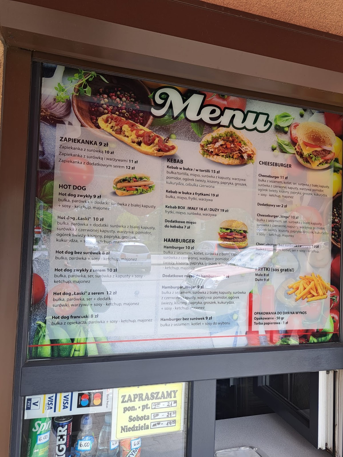 Karta menu w witrynie lokalu. Zapiekanki, hot dogi, kebaby, hamburgery, cheeseburgery z cenami.